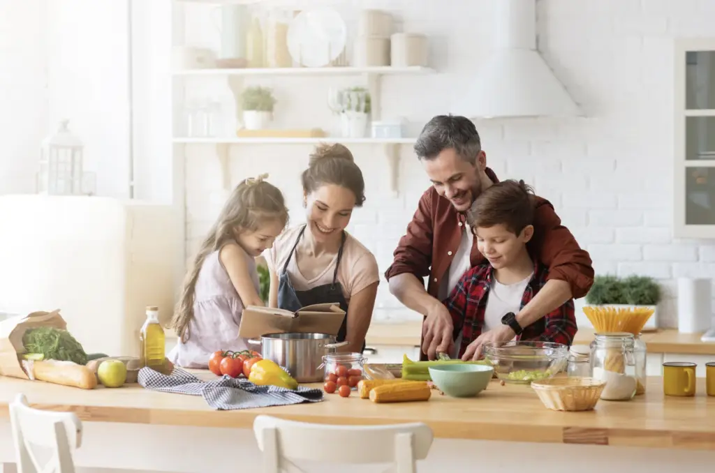 A white family smile as they chop vegetables in the kitchen