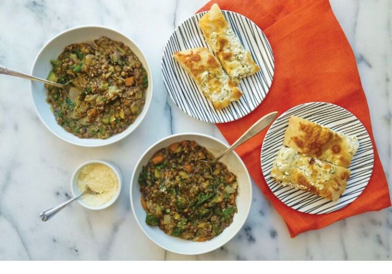 bowl of lentil stew with focaccia bread on the side